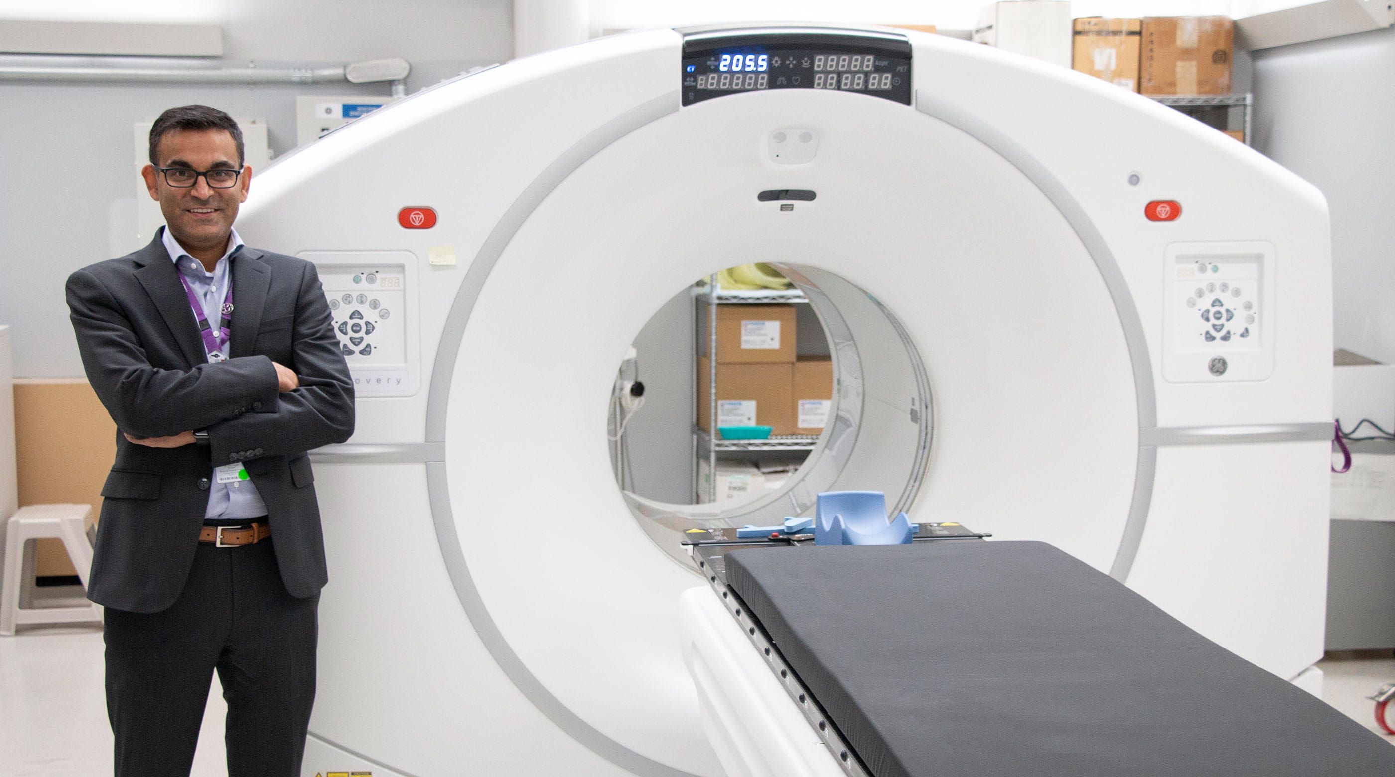 Dr Neil Vasdev standing in front of a PET scanning machine