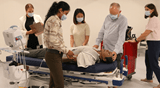 Sim team working on patient - wheeling in the crash cart